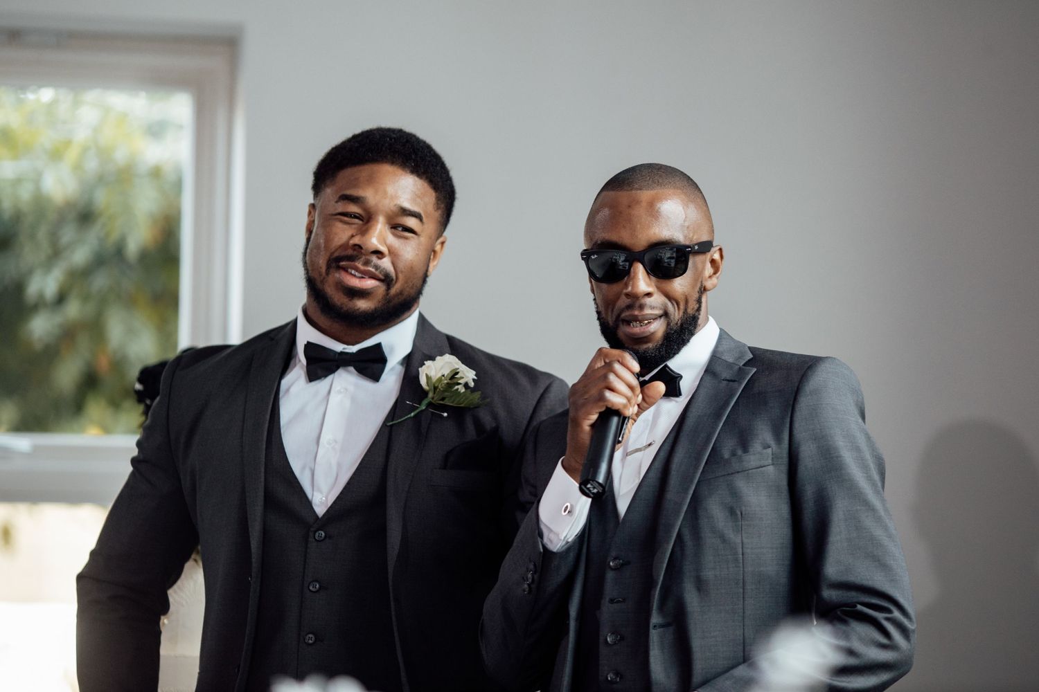 Groomsmen in formal black suits and bowties pose together before the ceremony.