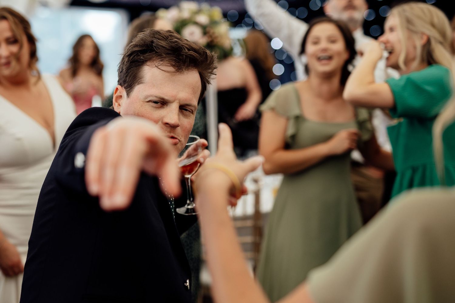 Wedding guests dance and celebrate during a lively reception party.