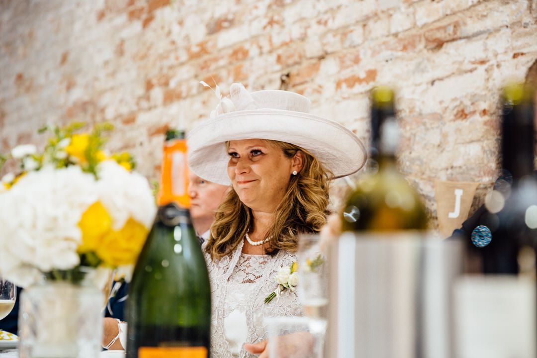 Elegant wedding reception setup with brick walls and floral arrangements.