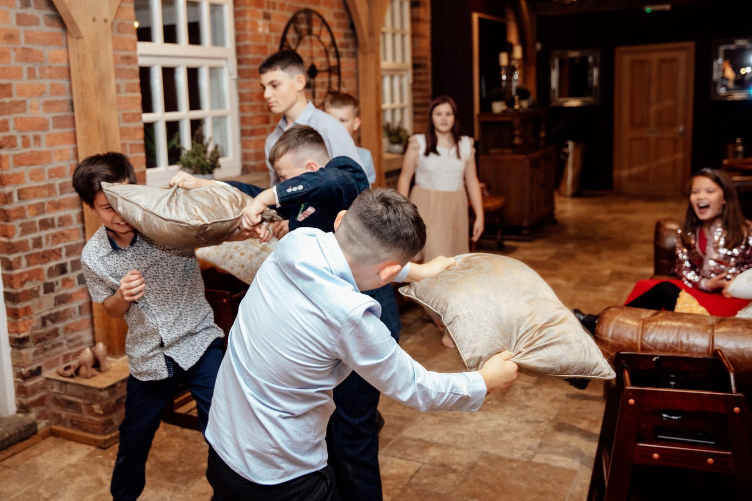 Lively wedding dance floor moments with guests celebrating at a rustic venue.