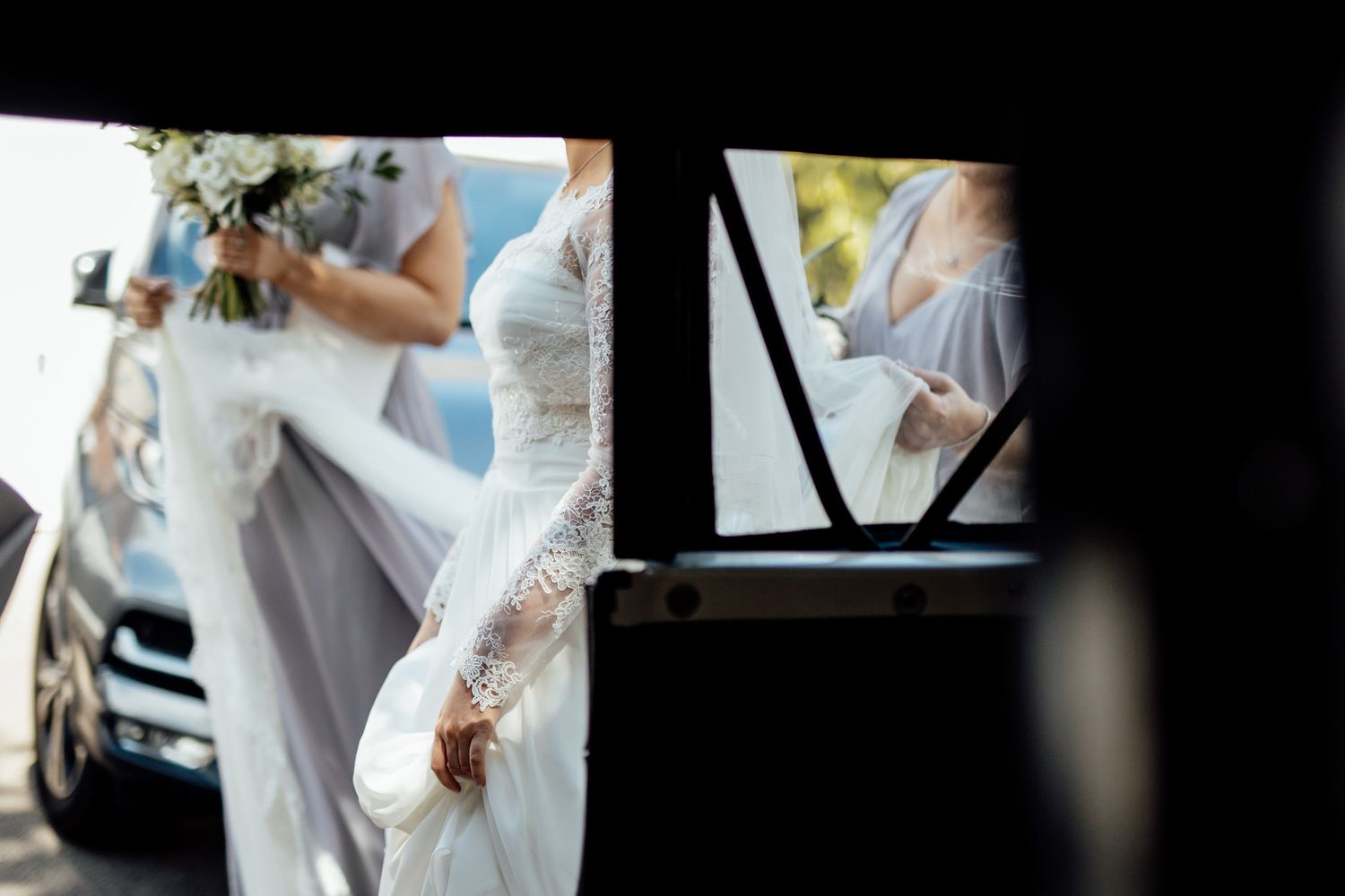 Wedding dress preparations showing intricate lace details and delicate fabric in natural light.