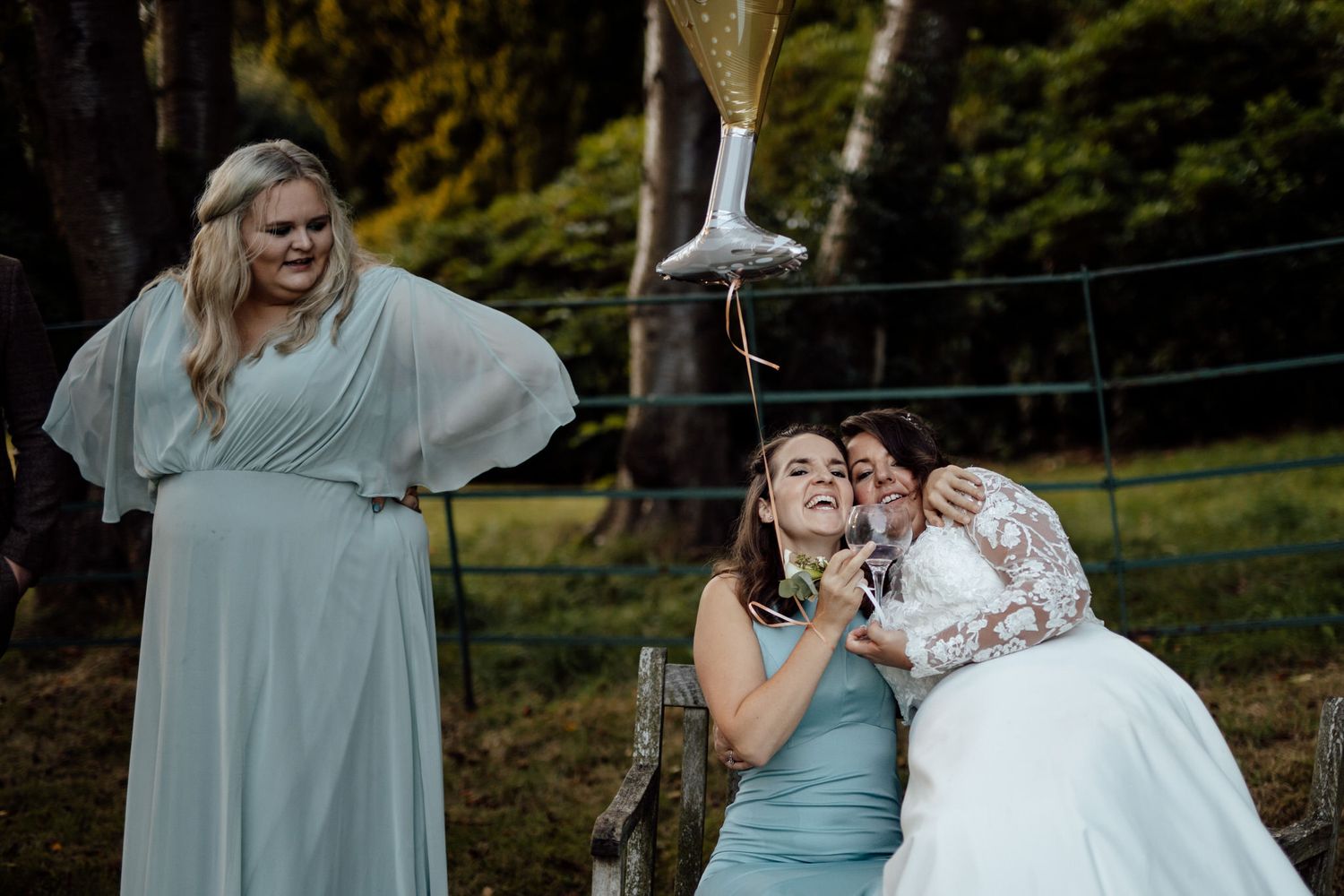Wedding party poses together outdoors in light blue bridesmaid dresses and formal attire.