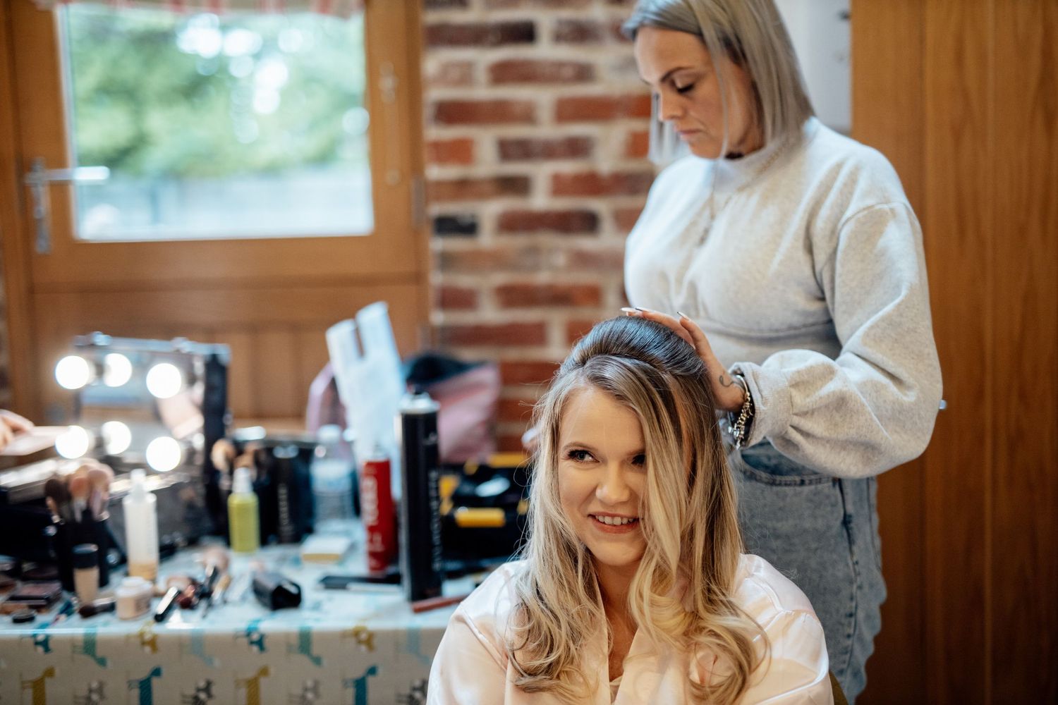 Wedding preparations in a rustic brick-walled room with natural lighting.