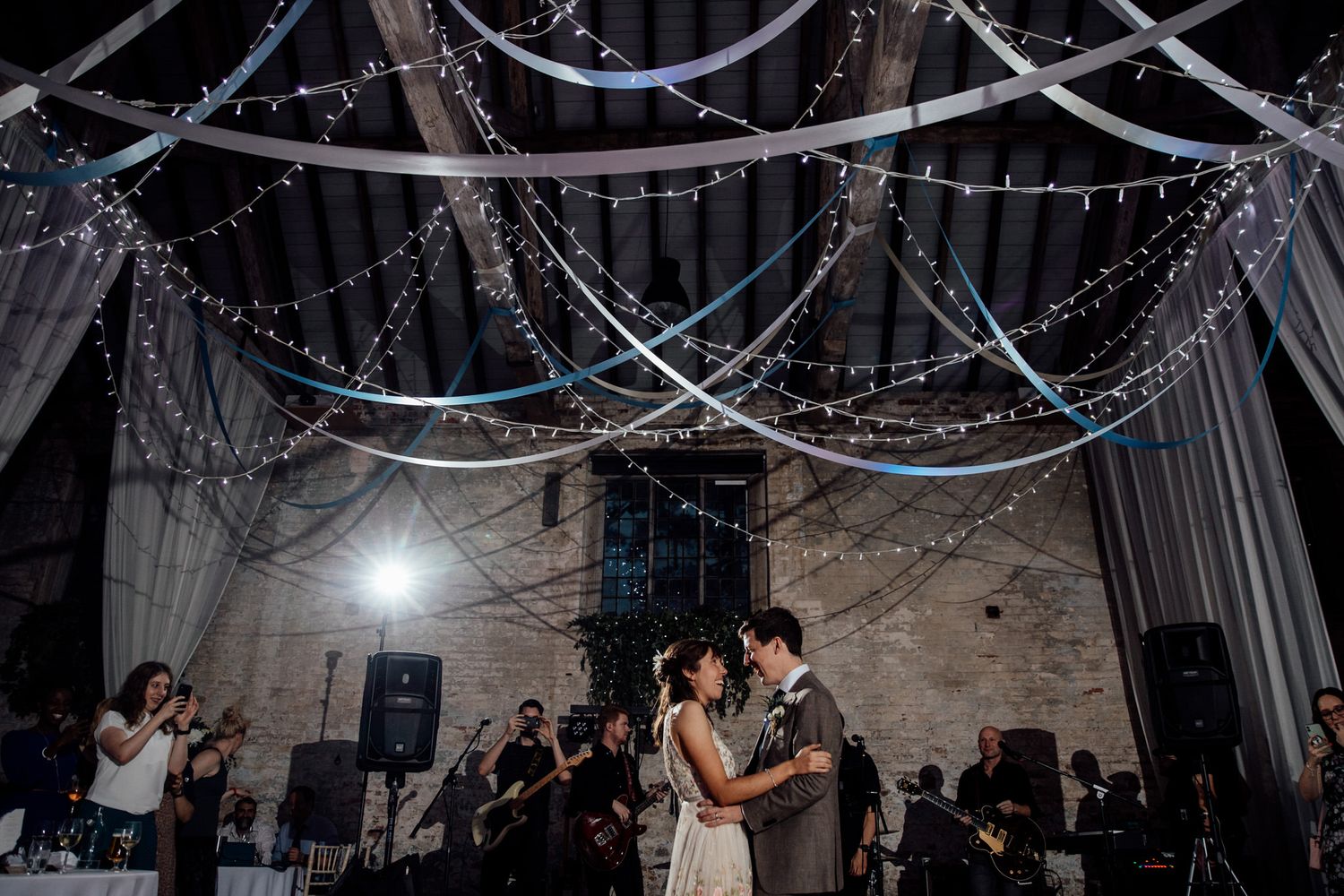 String lights and white fabric create a romantic canopy over wedding venue.