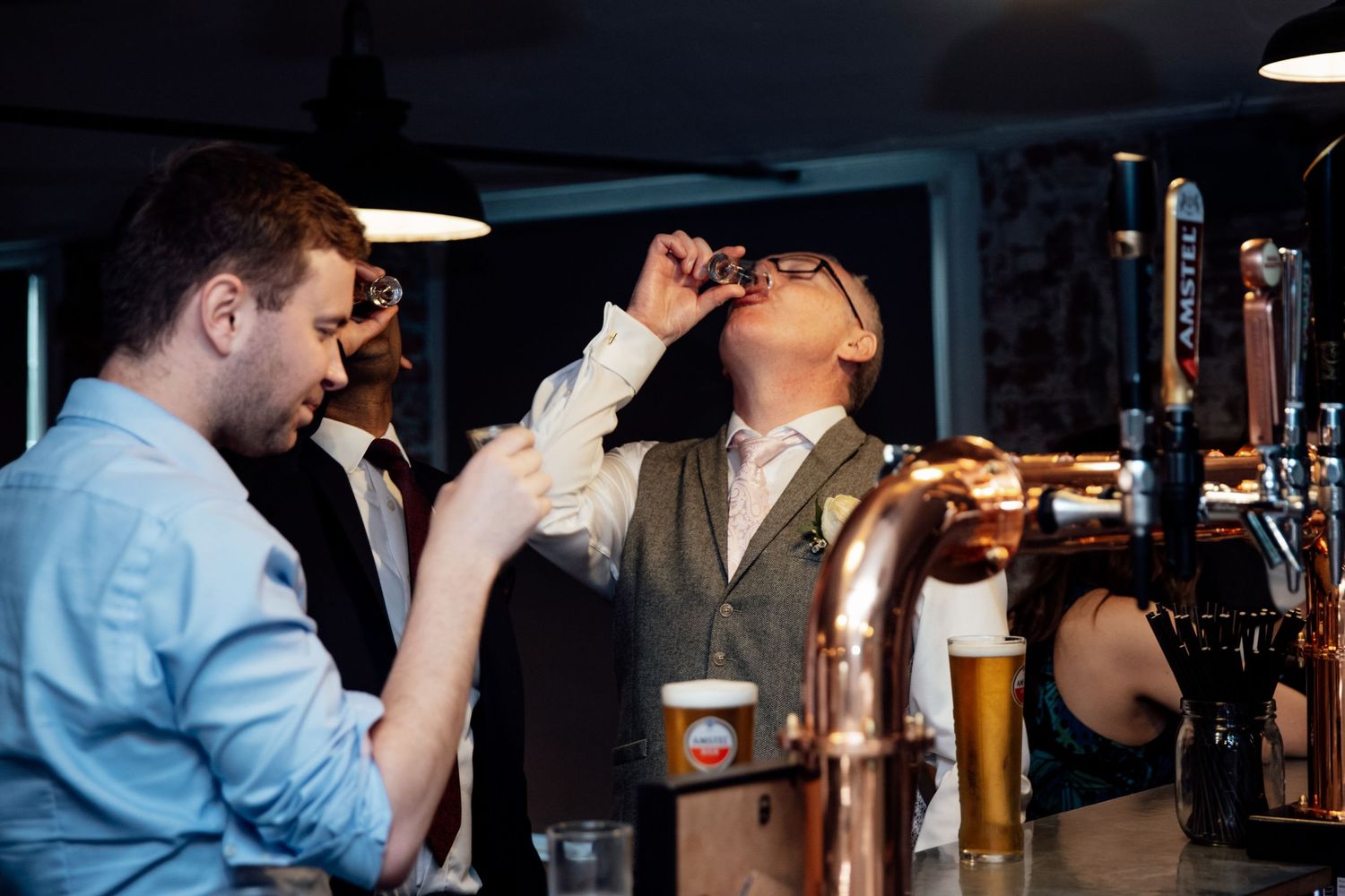 Bar scene with guests enjoying drinks and conversation at an evening celebration.