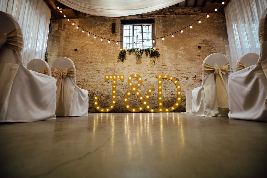 Wedding venue interior decorated with white draping and romantic string lights.