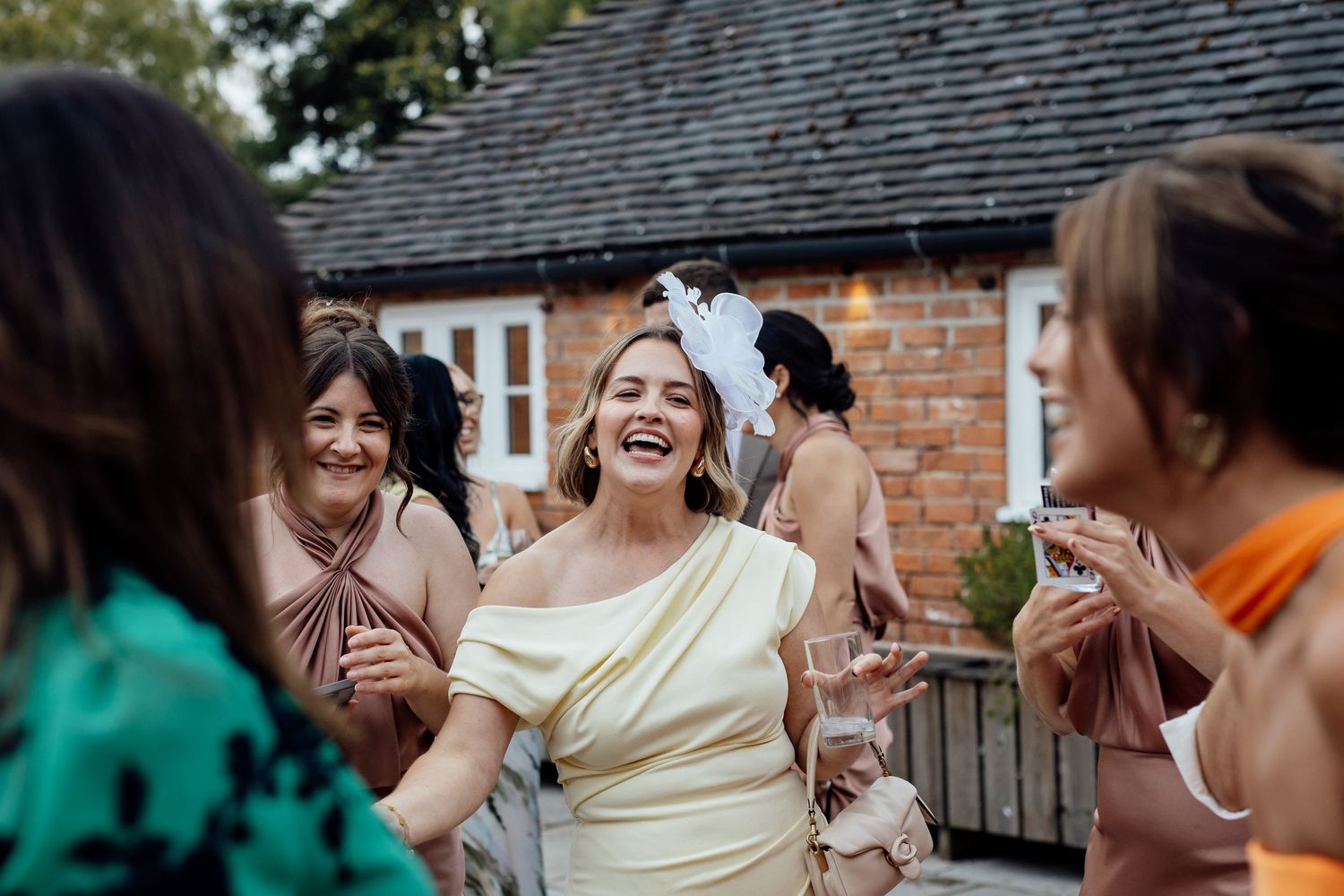 Wedding guests laughing and celebrating during outdoor reception.