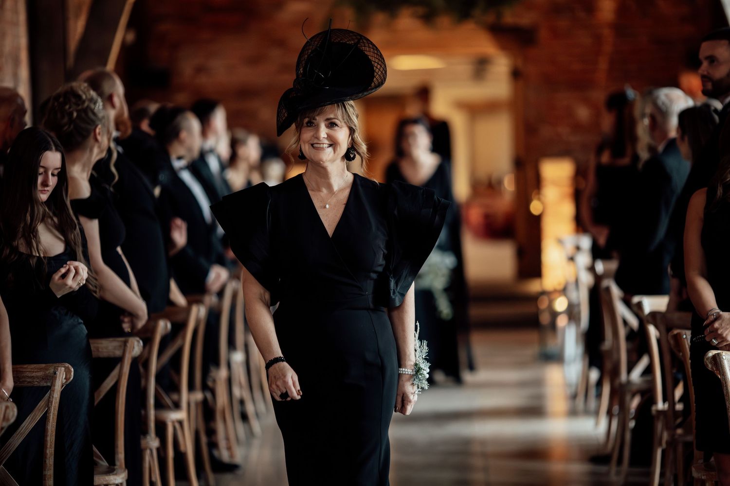 Wedding guests in formal attire mingle during an elegant indoor reception.