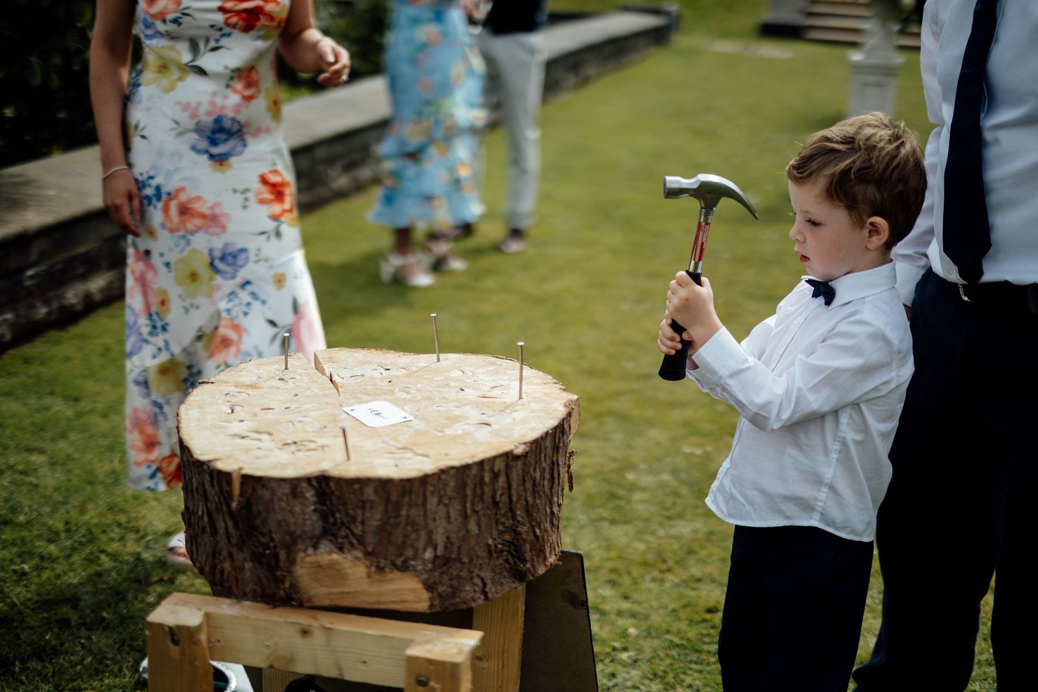Children playing with wooden decor pieces at an outdoor wedding.