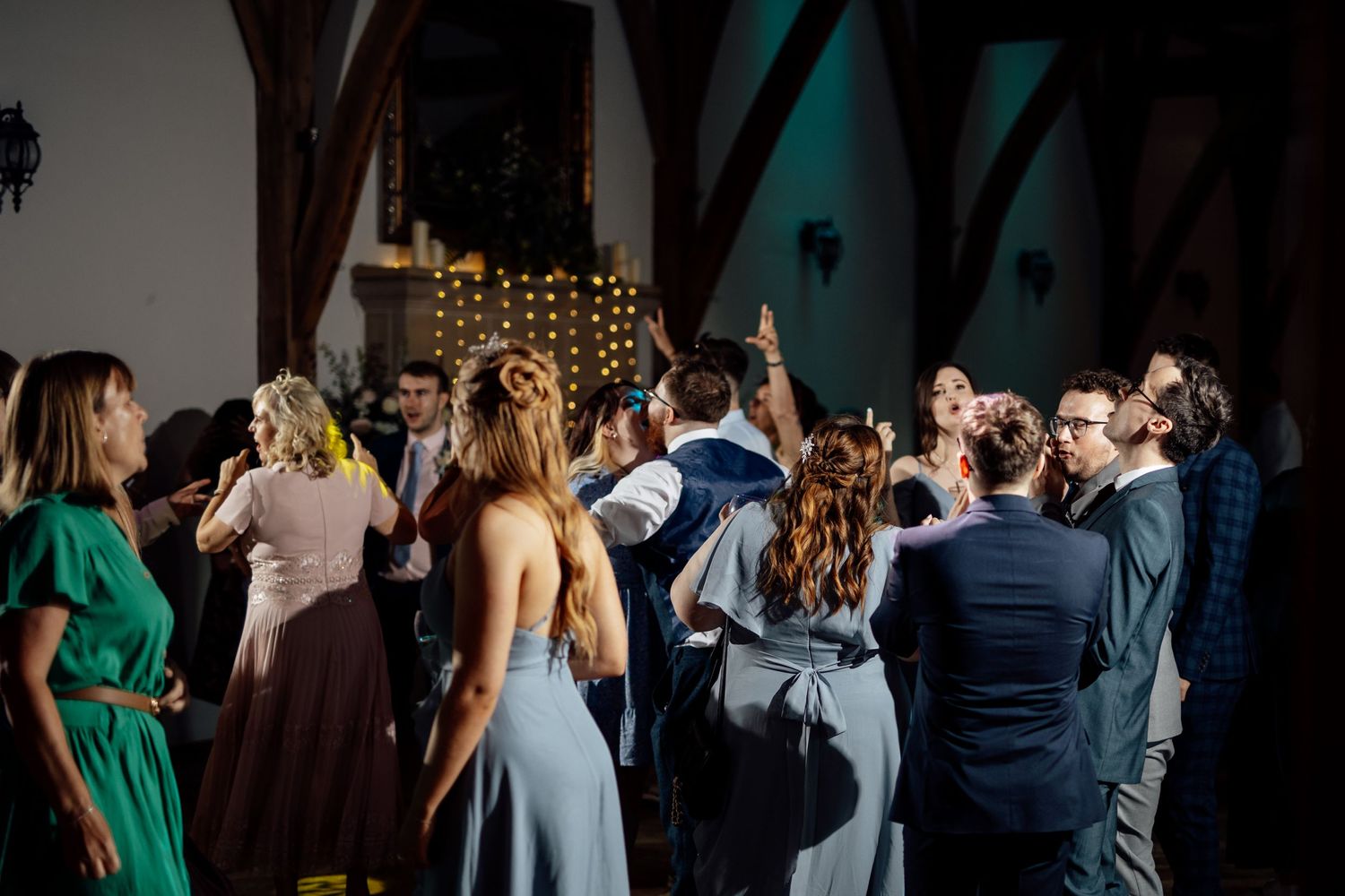 Dark and moody reception venue with guests gathered for celebrations.