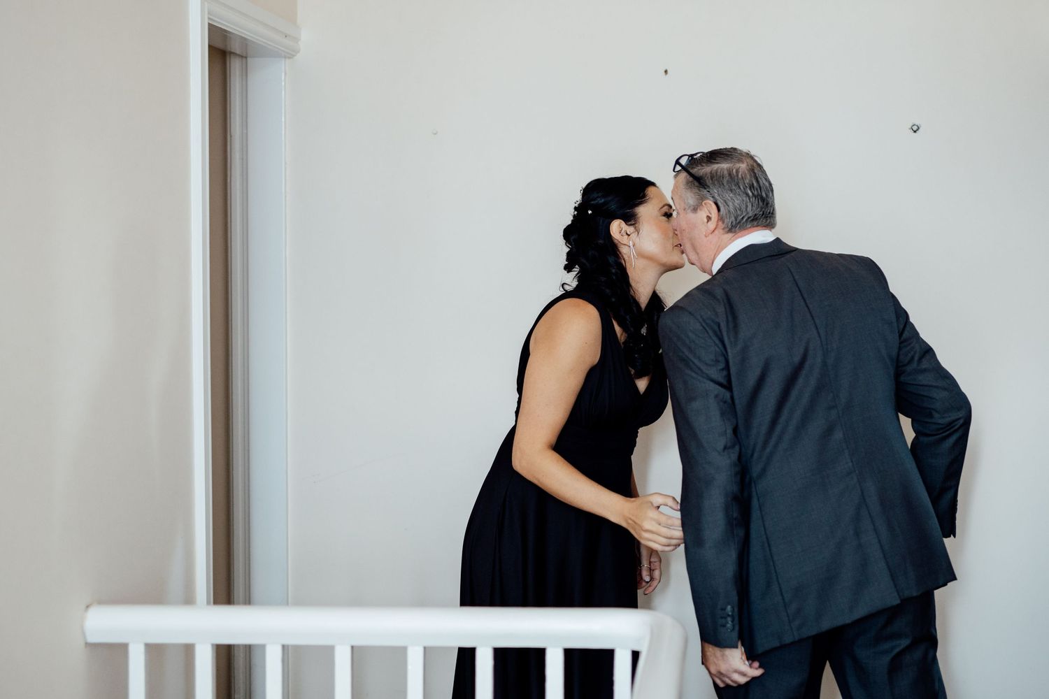 Intimate moments shared during wedding reception in white interior space.