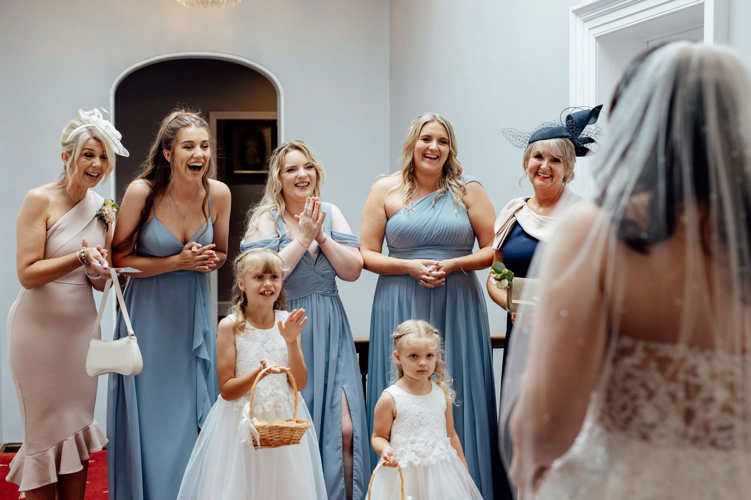 Wedding celebration with guests in light blue dresses during indoor ceremony.