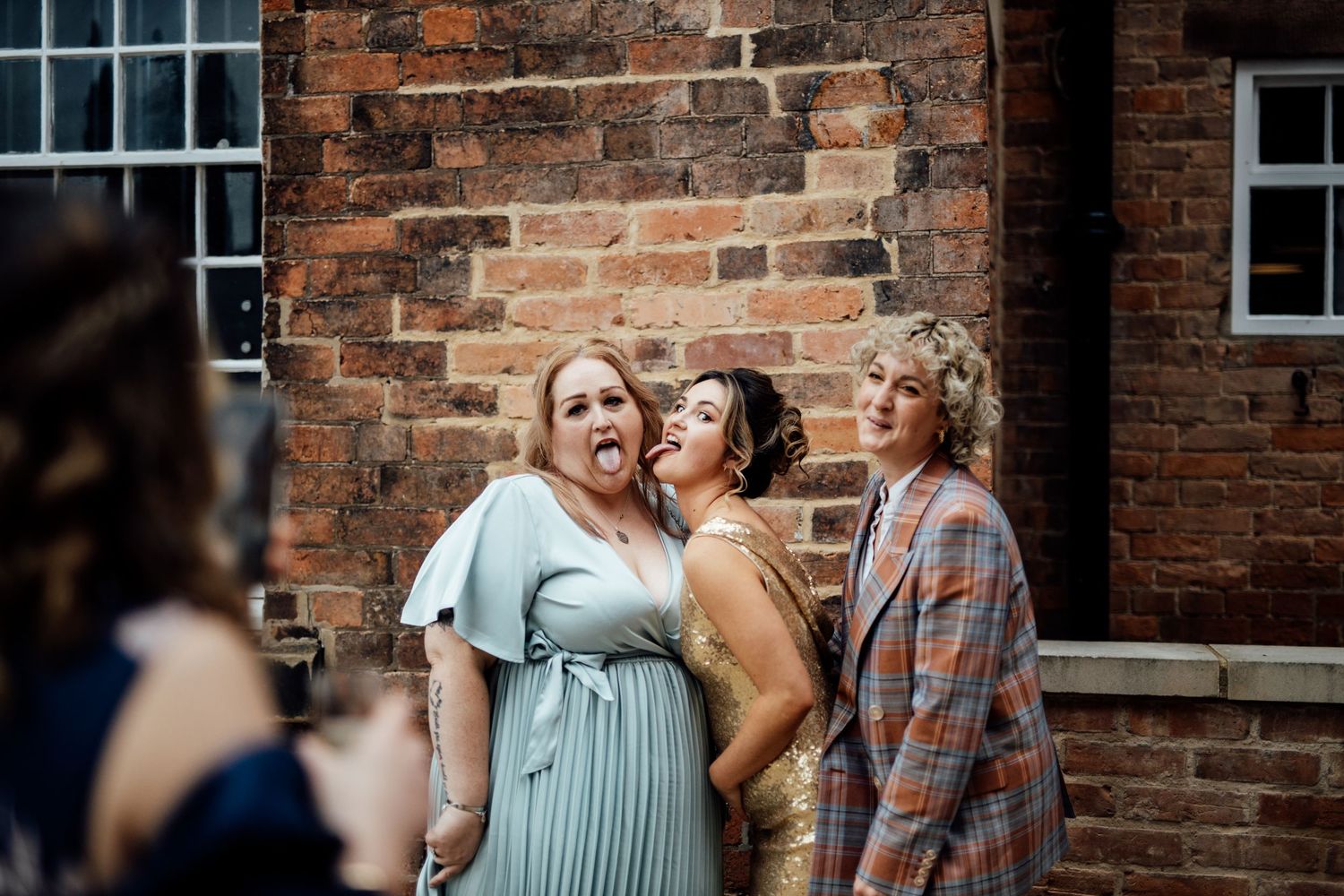 Guests gather at a wedding celebration against exposed brick walls.