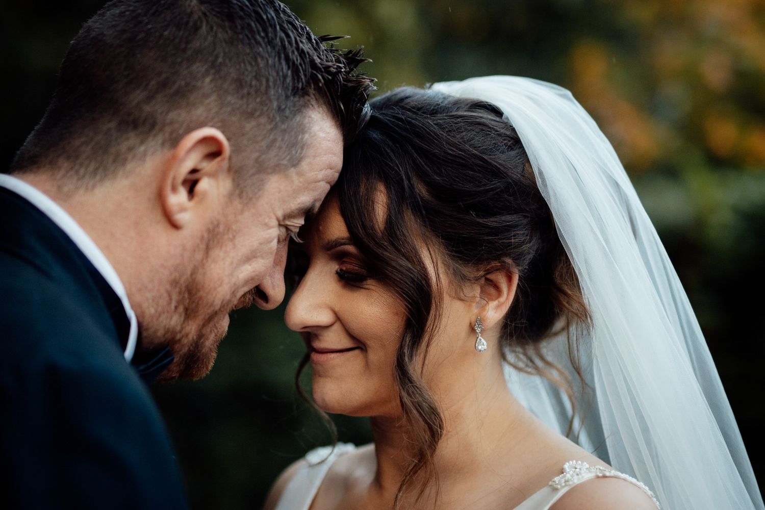 Intimate wedding couple portraits captured during golden hour in a garden setting.