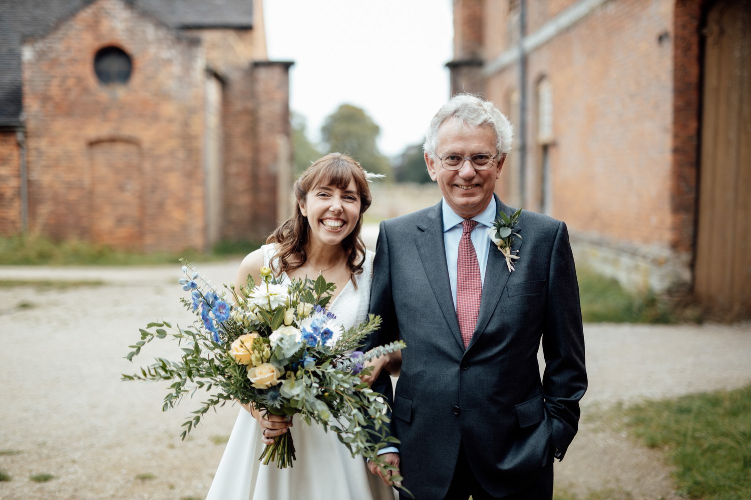 Outdoor gathering at a rustic brick venue with natural landscaping.