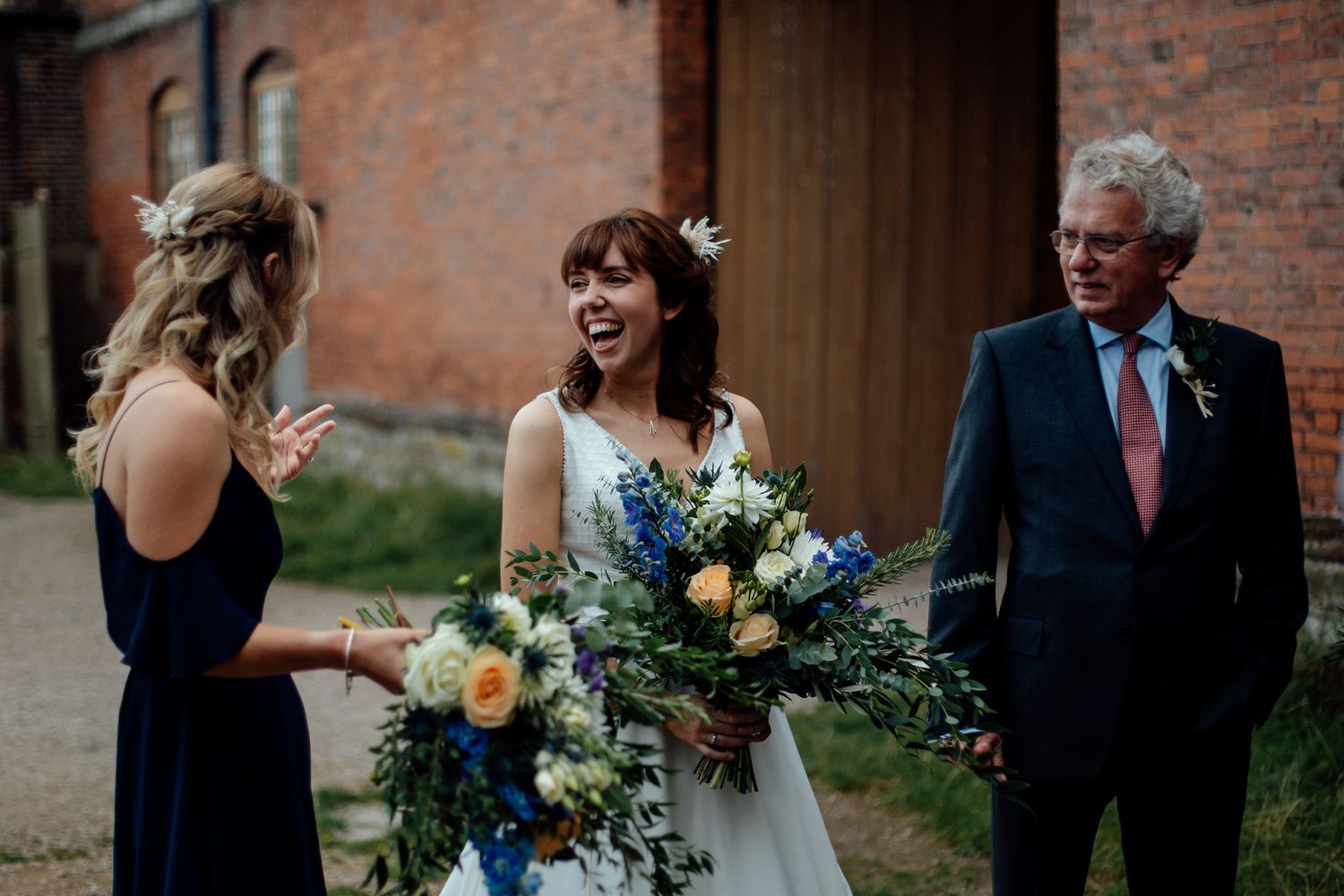 Wedding party gathered outdoors near a historic brick building during celebration.
