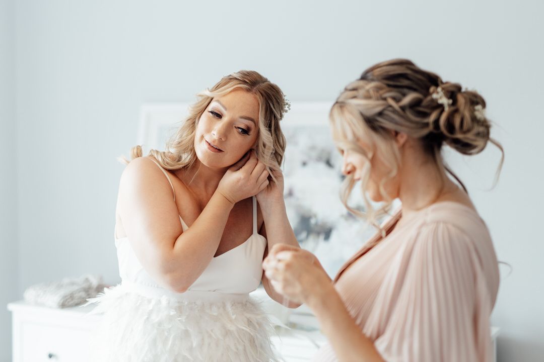 Bridal party wearing pastel dresses gather for candid pre-wedding photos.