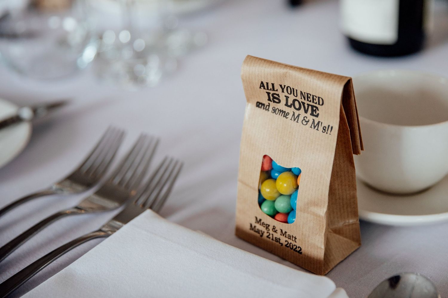 Wedding favor bags and place settings arranged on elegant dining tables.