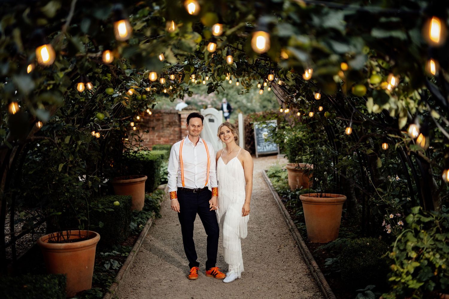 Garden pathway illuminated with string lights creating romantic wedding ambiance.