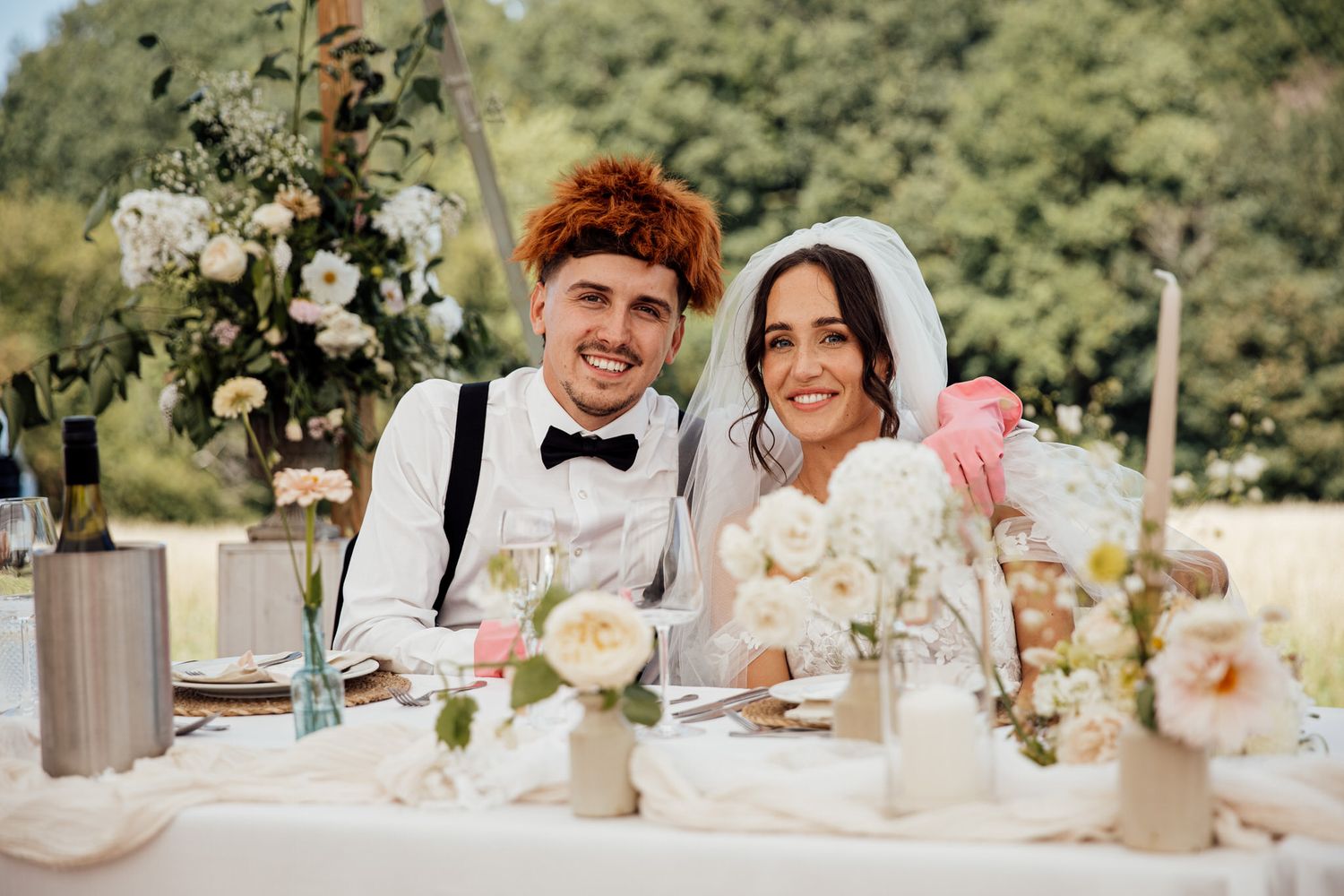 Outdoor wedding reception tables decorated with delicate floral arrangements and white linens.