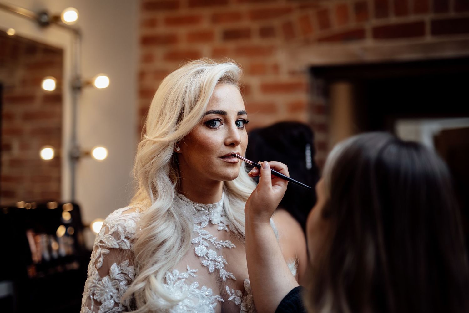 Wedding preparations in an industrial-chic venue with exposed brick walls.