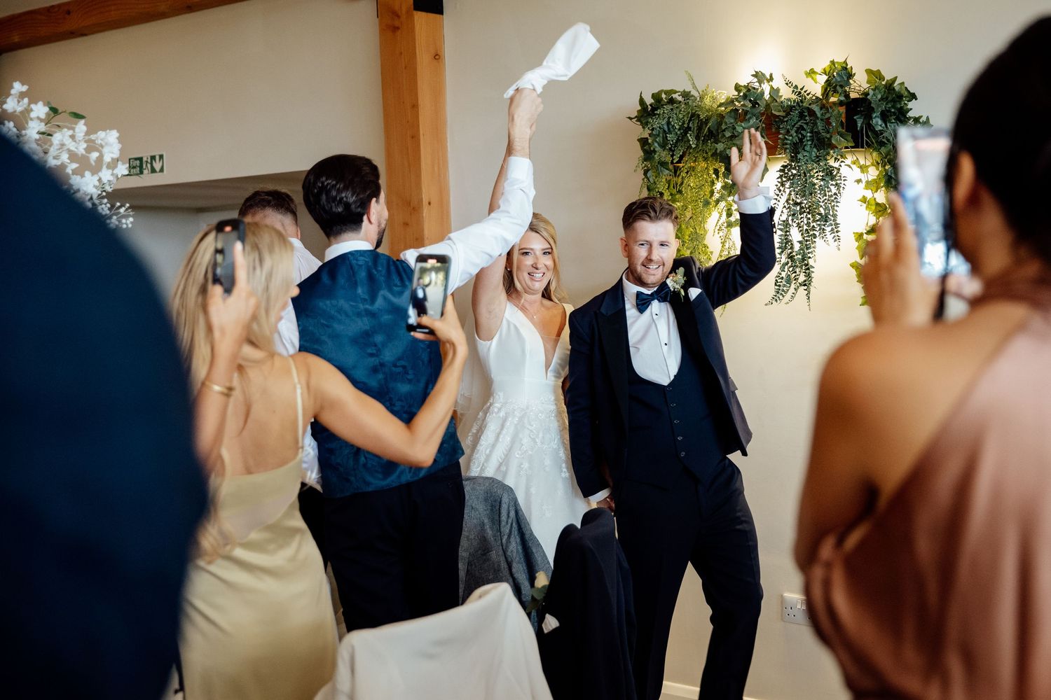 Wedding guests dancing and celebrating during an indoor reception party.