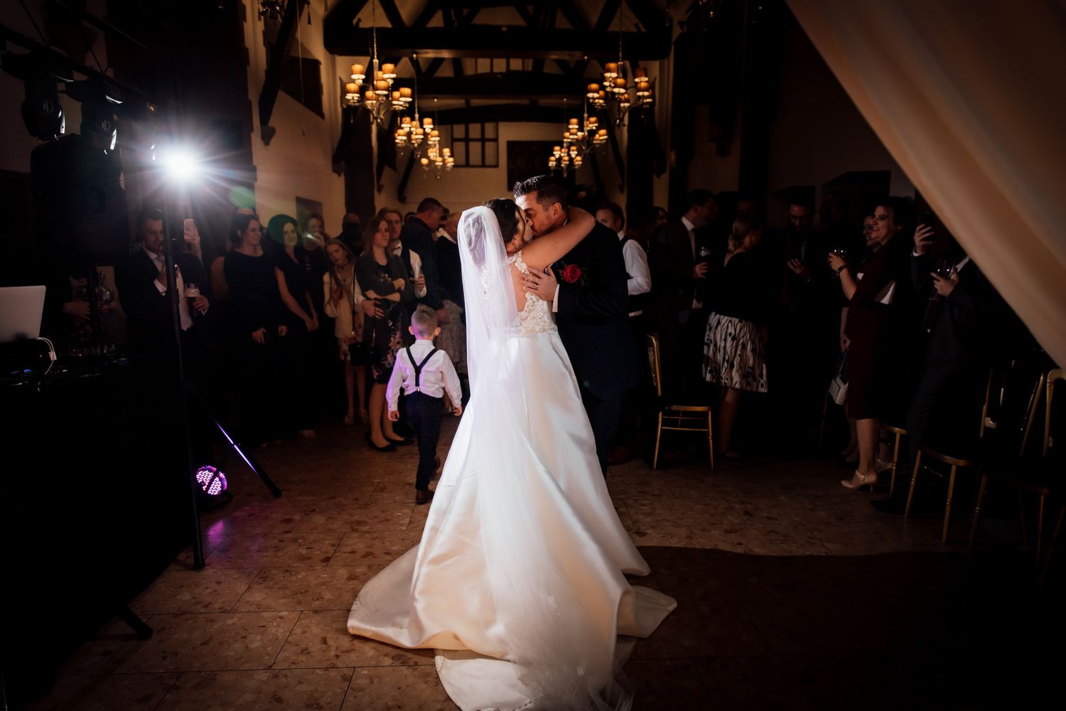 Wedding reception dance floor moments captured in dramatic lighting.