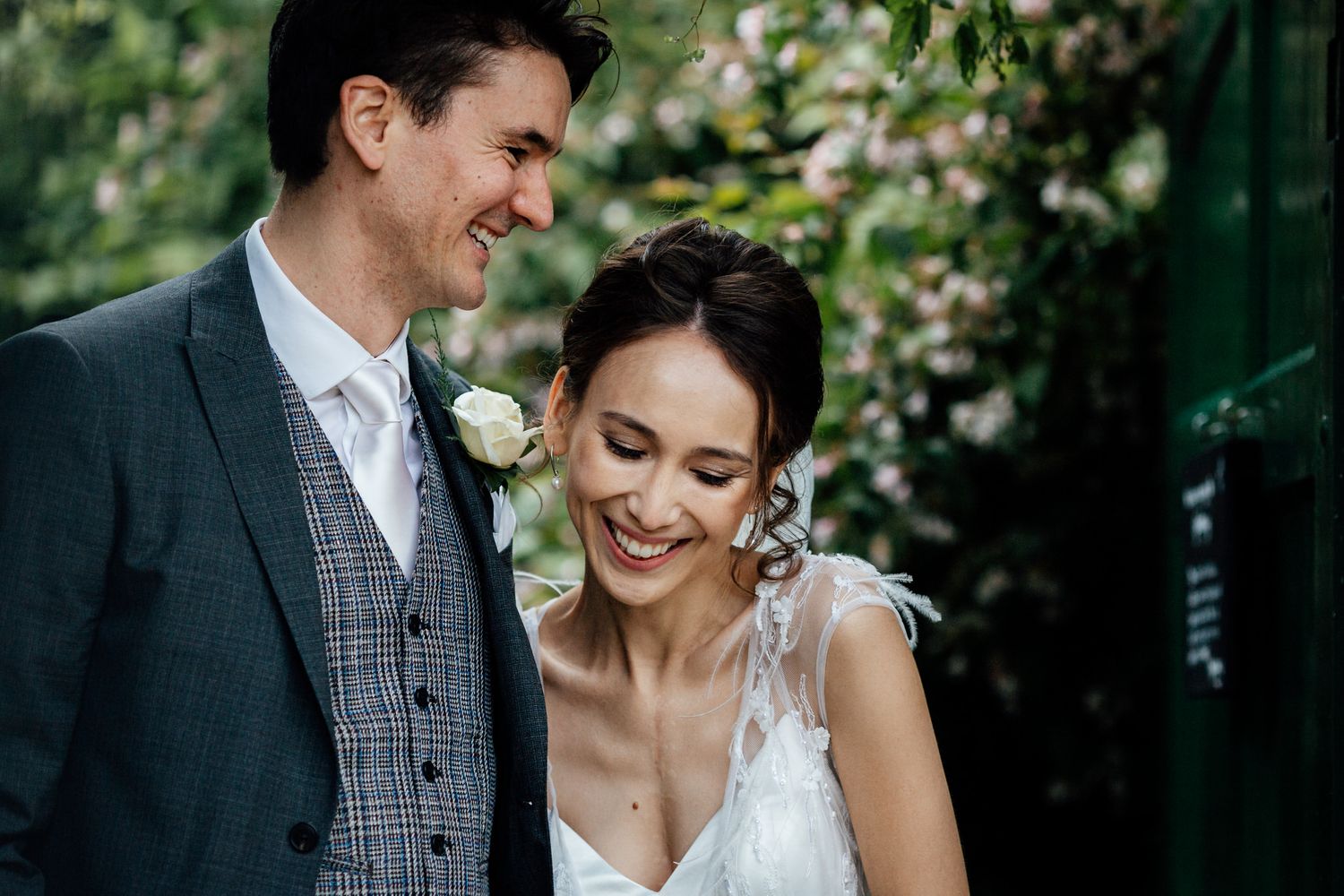 Couple sharing intimate moment in garden setting during wedding.