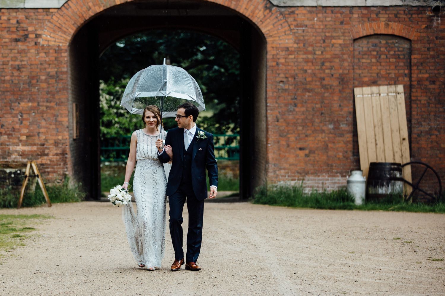 Romantic wedding moments captured under brick archways in a rustic courtyard.