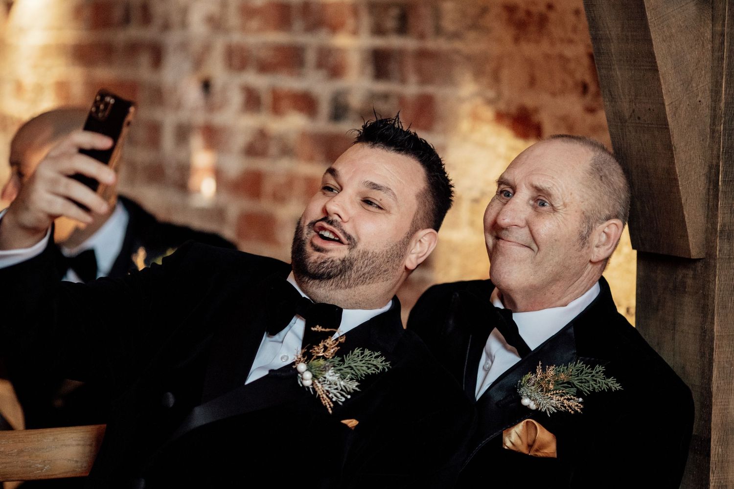 Wedding celebration at a rustic brick venue with formal attire and natural lighting.