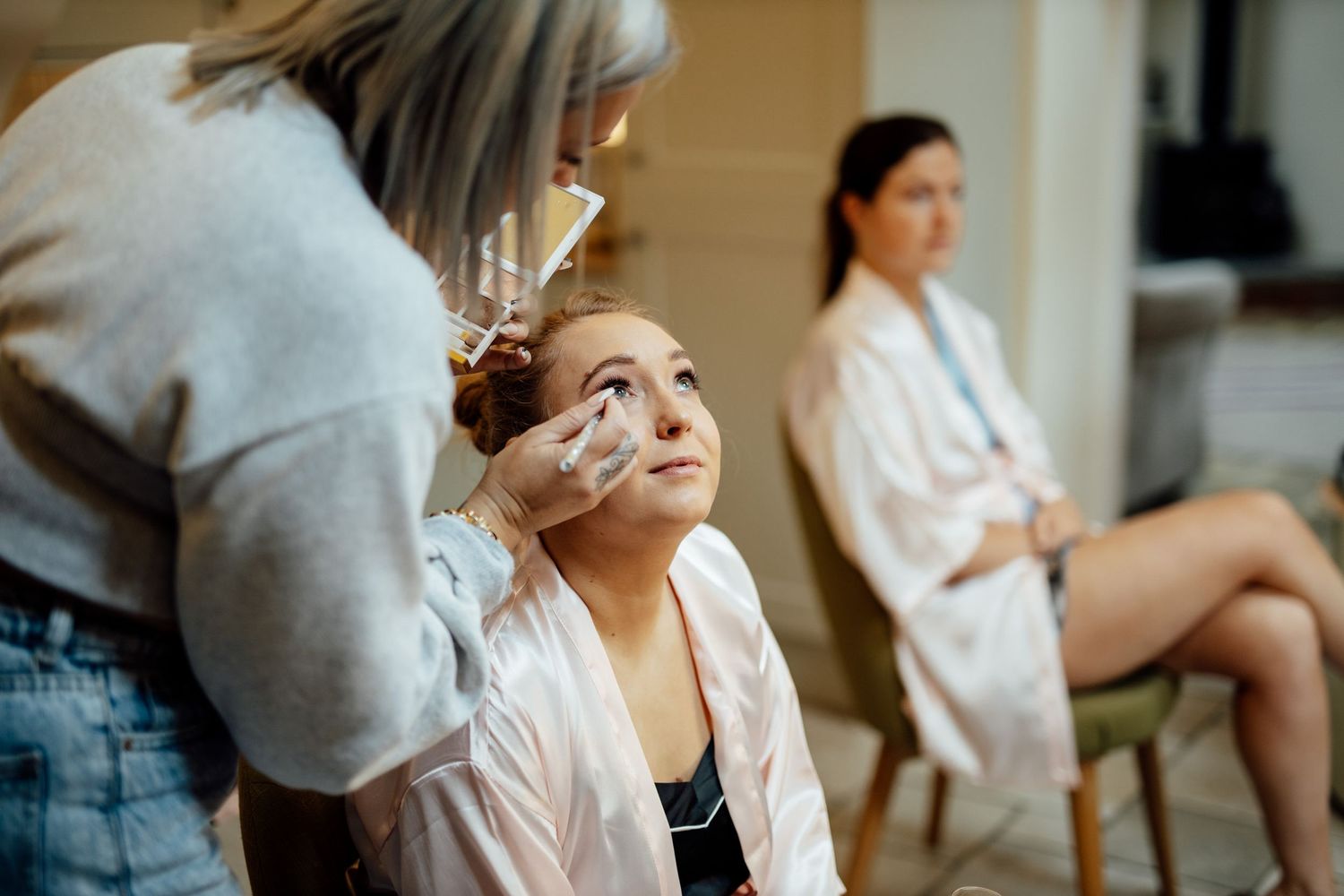 Wedding preparation scene in a bright room with natural lighting.