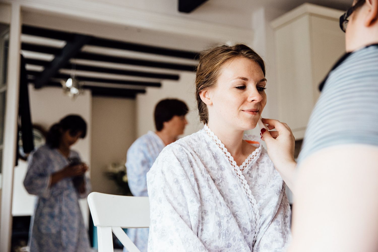 Wedding day preparations in a bright room with white decor.