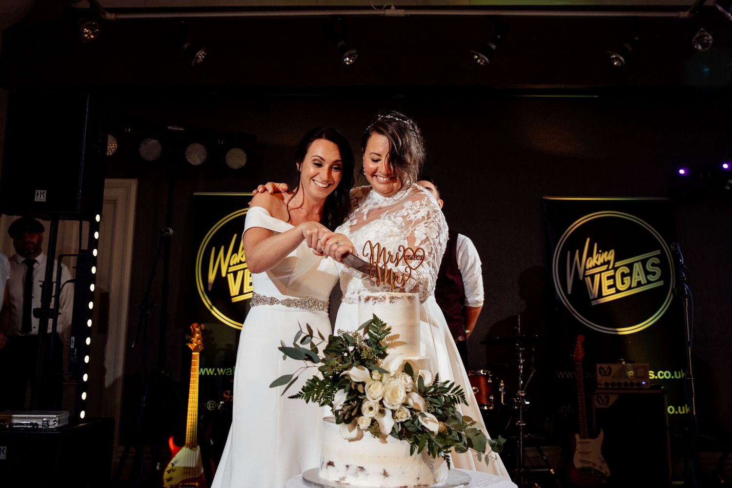 Wedding celebration in a dimly lit venue with decorative lighting and festive atmosphere.