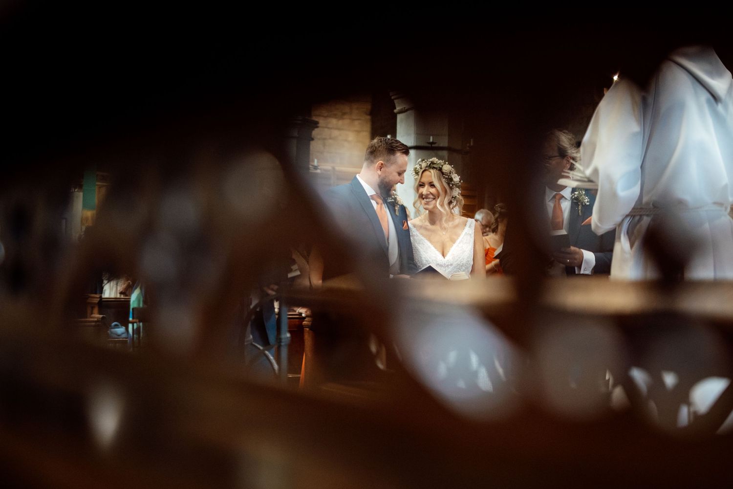 Artistic wedding reception photo captured through glass with bokeh and reflections creating a dreamy atmosphere.