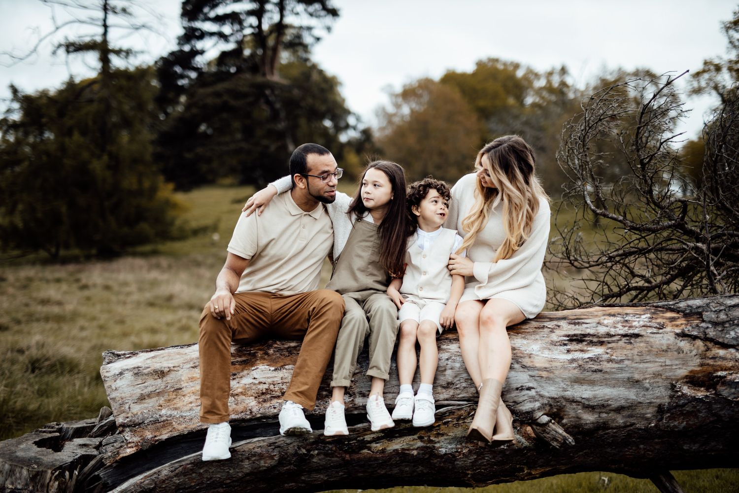 Family sitting together on natural rock formations during an outdoor photo session.