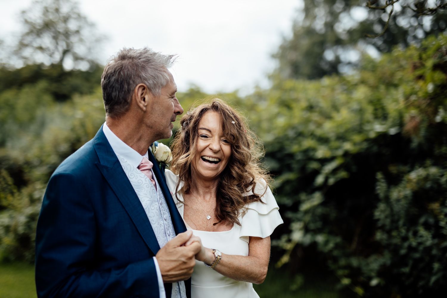 A romantic moment captured between a couple laughing together outdoors.