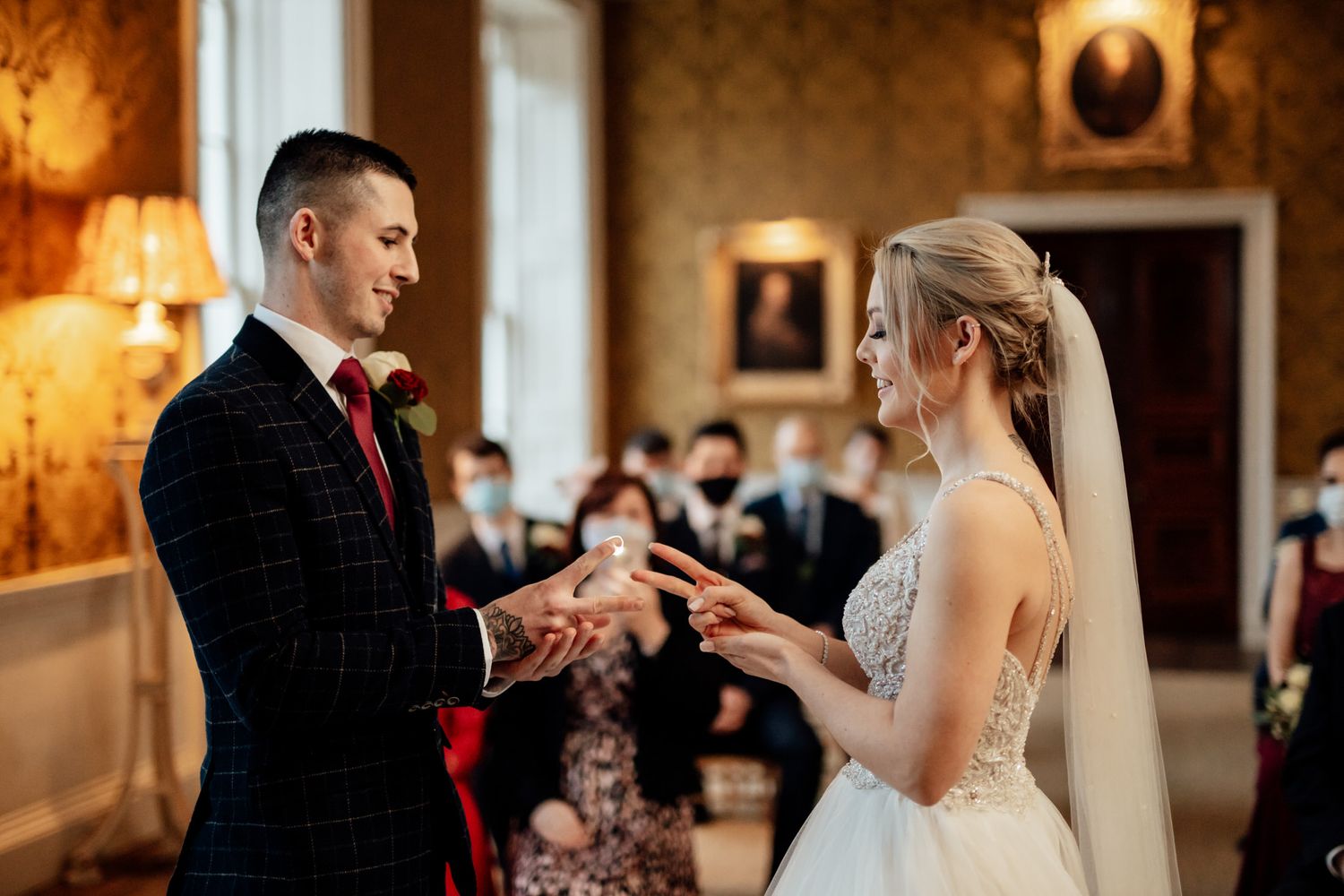 Romantic wedding ceremony in an ornate ballroom with warm lighting and classic columns.