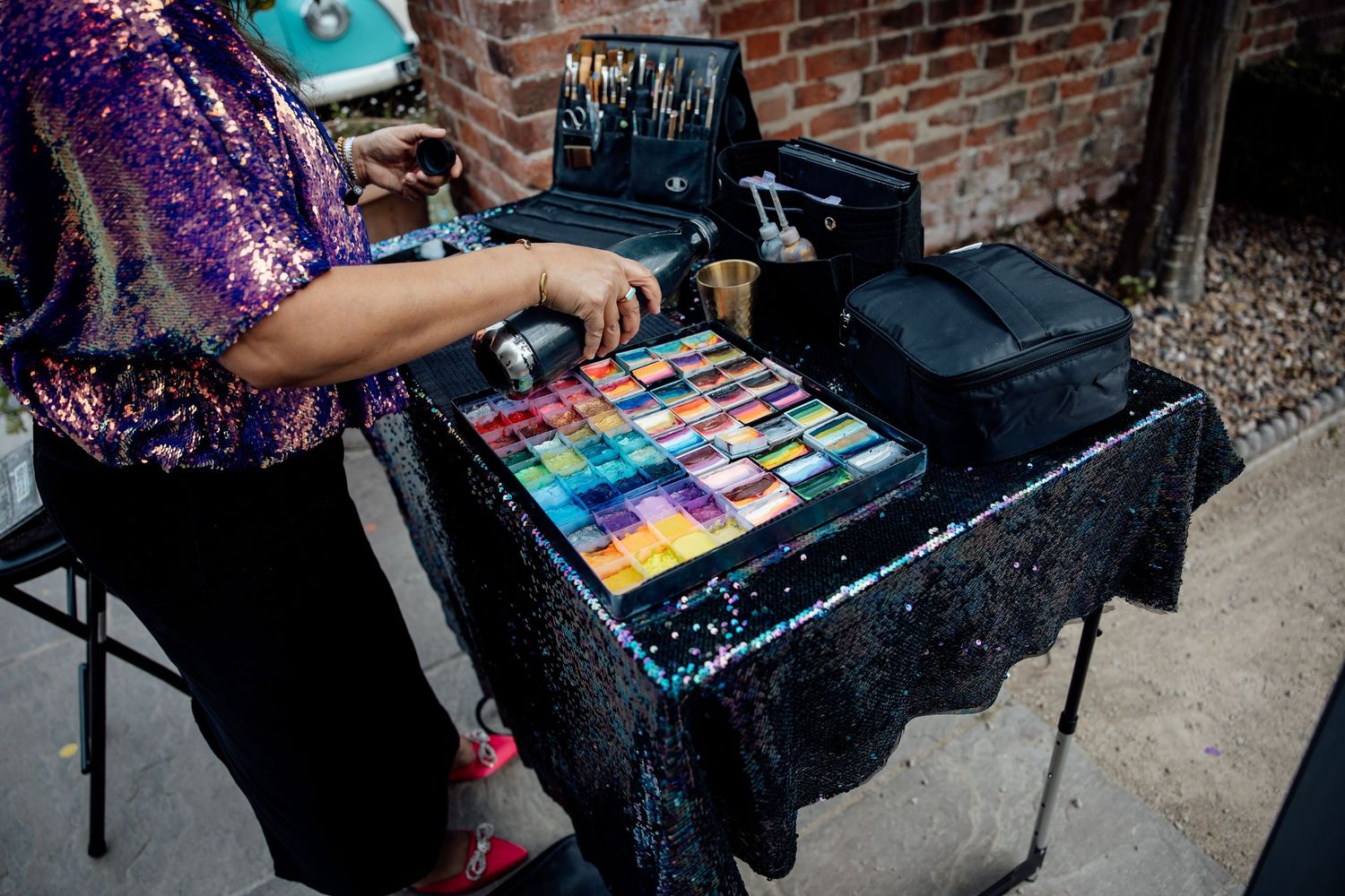 Colorful paint splatter art activity on black surface at wedding reception.