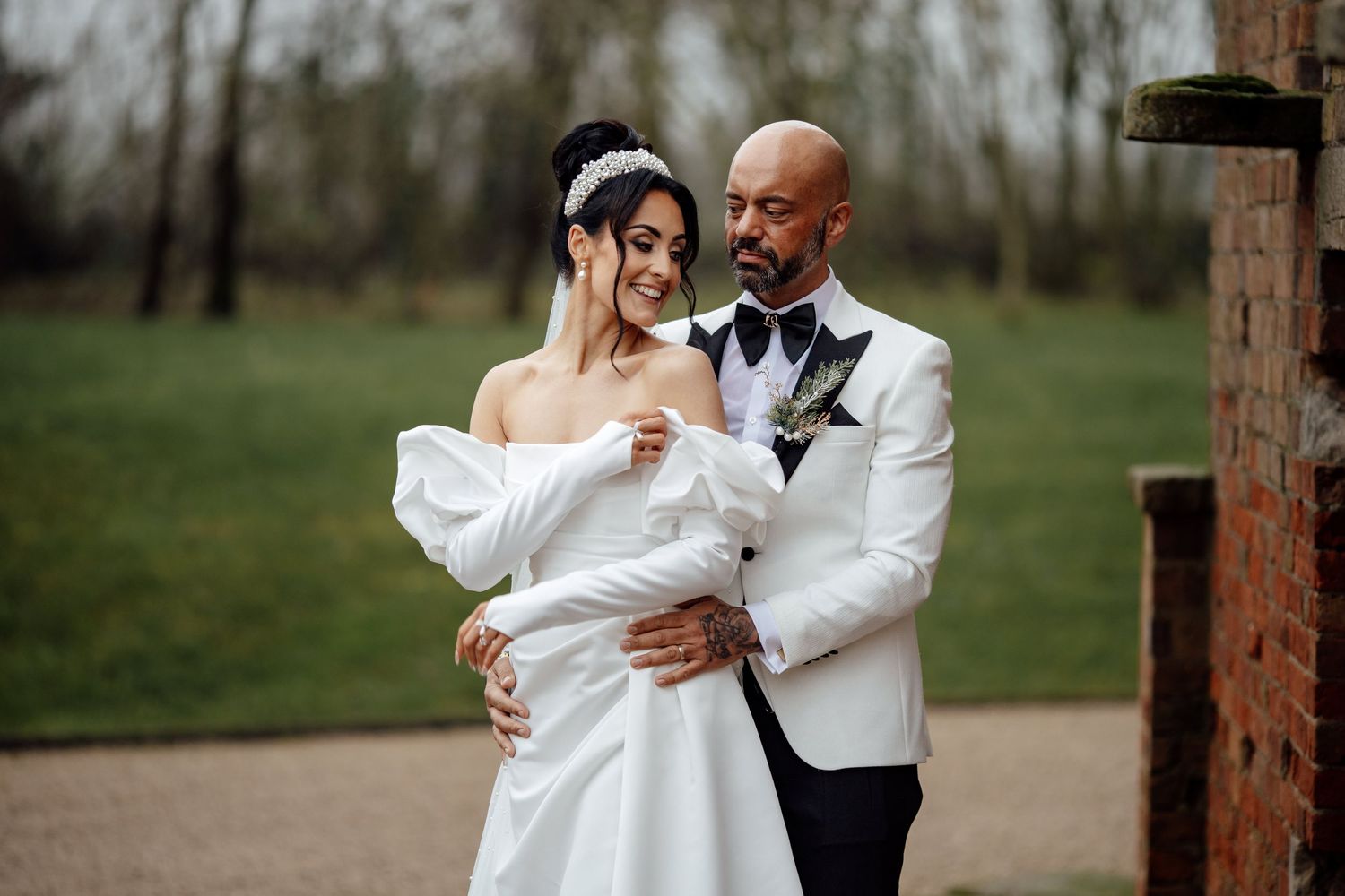 A couple shares romantic moments in an outdoor garden setting during their wedding.