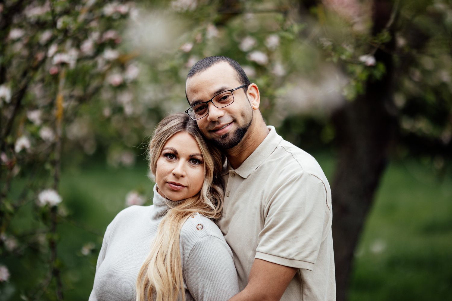 A couple shares intimate moments in a blooming spring garden setting.