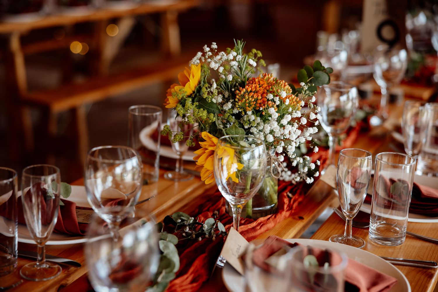 Elegant table settings with wine glasses and floral arrangements at a wedding reception.
