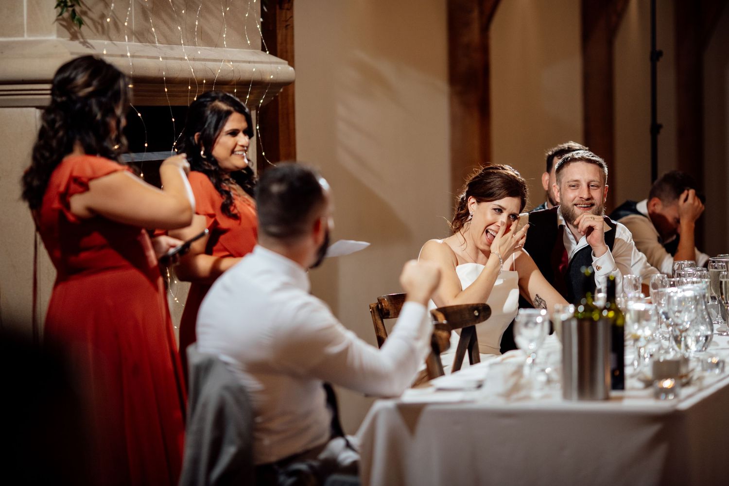 Wedding reception guests enjoying dinner and conversation at elegantly set tables.