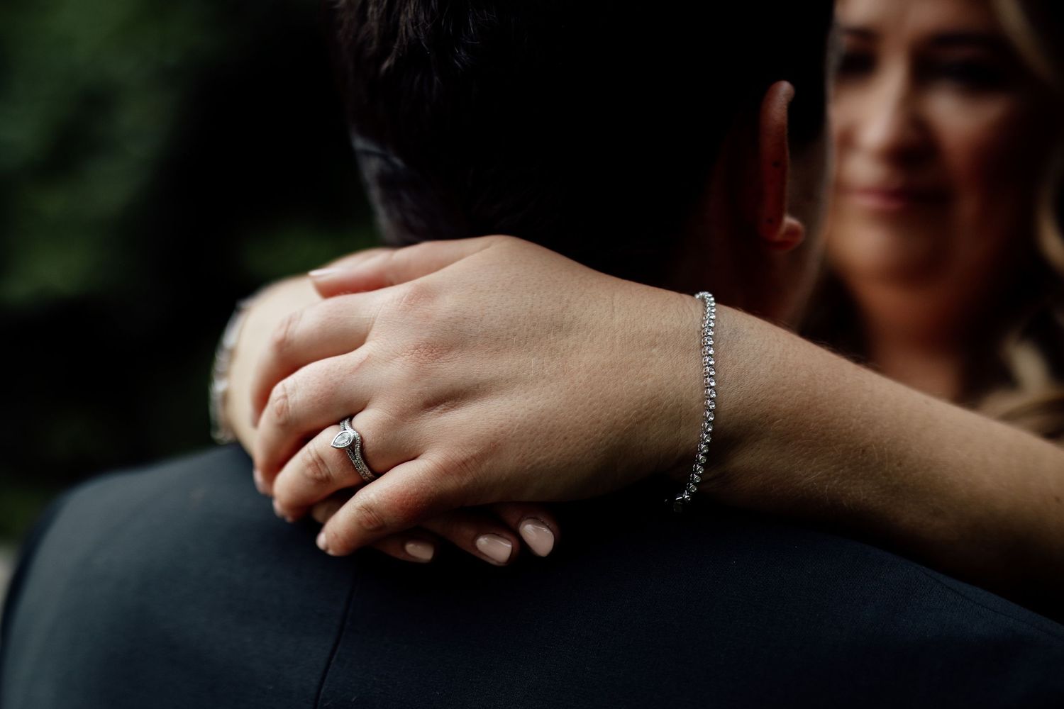 Close-up details of hands and jewelry during wedding celebrations.
