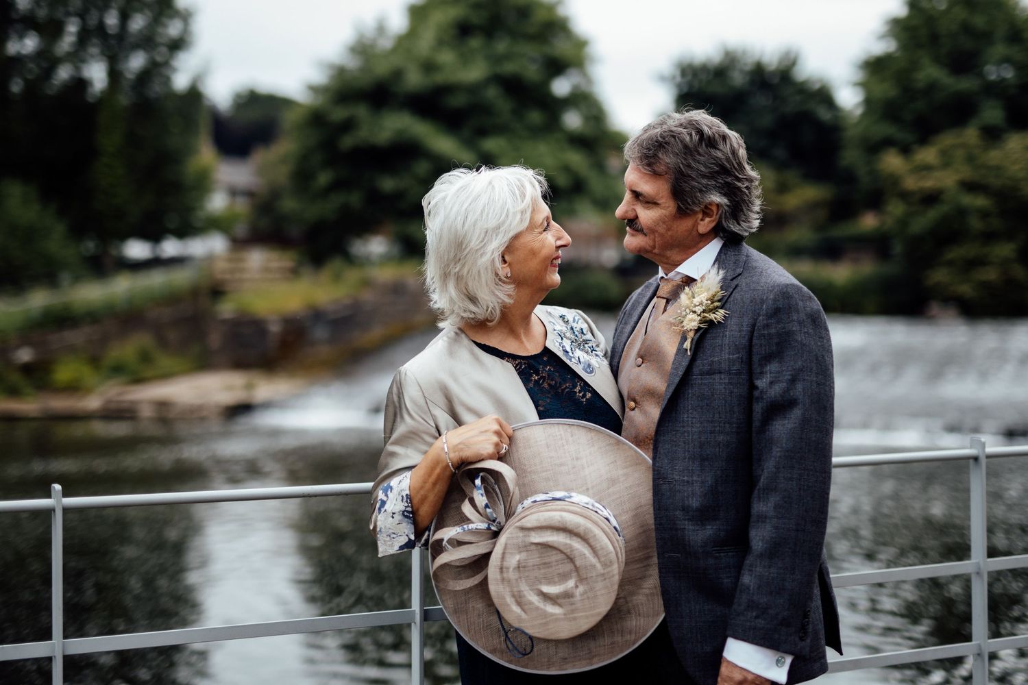 Romantic moment captured on a waterfront terrace during a wedding celebration.