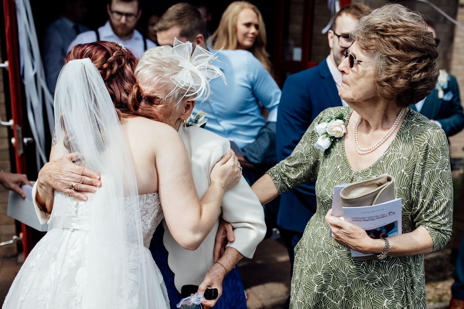 Wedding guests embrace and share emotional moments during the reception.