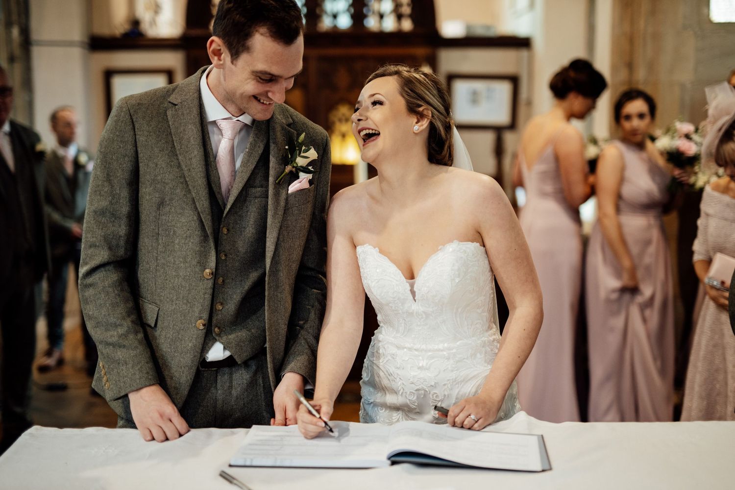 Wedding ceremony with couple signing marriage documents at the altar.