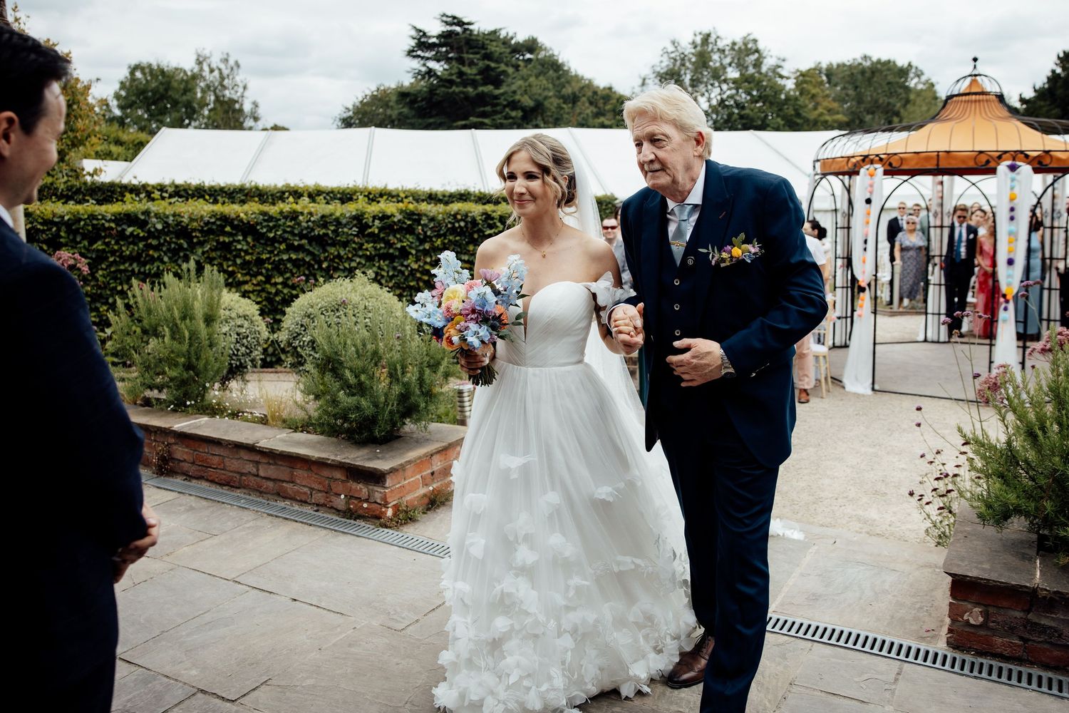 Wedding ceremony at a garden venue with elegant floral decorations.