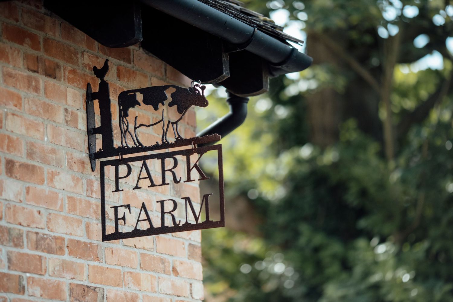 Rustic brick wall with decorative farm signage and black metal accents.