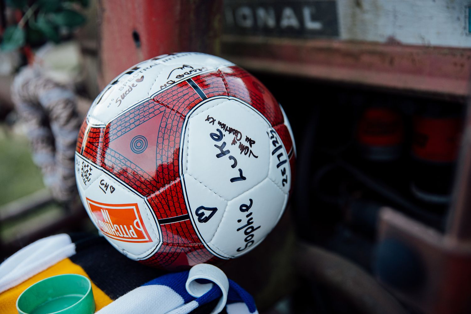 Collection of red and white soccer balls arranged on display.