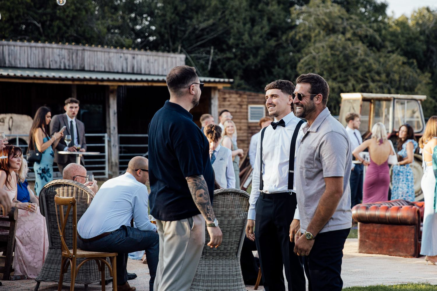 Wedding guests mingle and socialize at outdoor rustic venue reception.